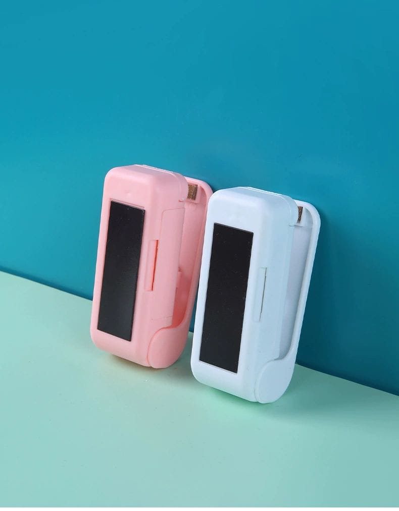 Two small electronic devices, one pink and one white, on a teal surface with a blue background.