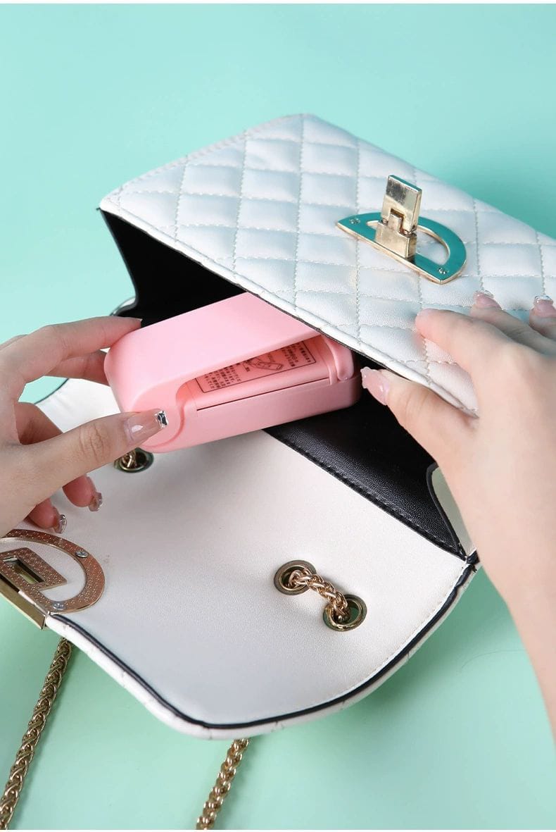 White quilted handbag with gold chain strap on a light blue background