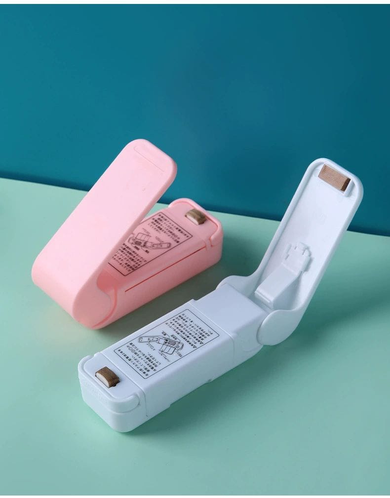 Two small electronic devices, one pink and one white, on a teal surface with a blue background.