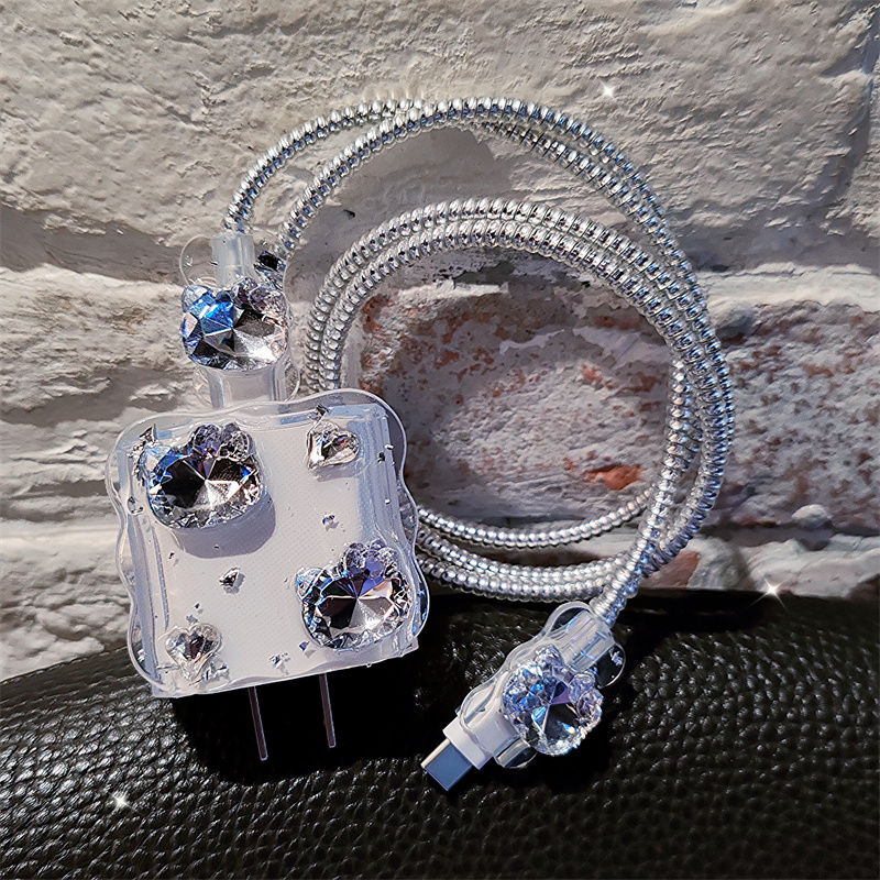 Crystal-encrusted earbud with coiled cable on a textured surface