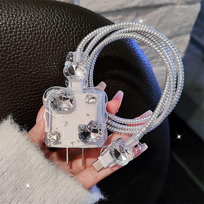 Clear phone case with rhinestone accents held by a hand against a dark background
