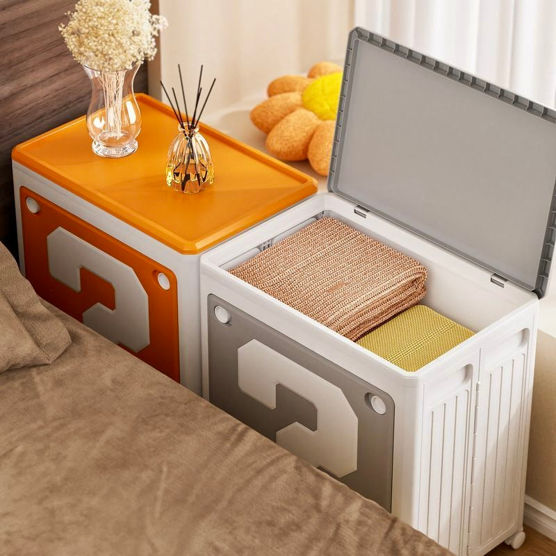 Storage bench with open lid revealing folded blankets, placed against a neutral wall.