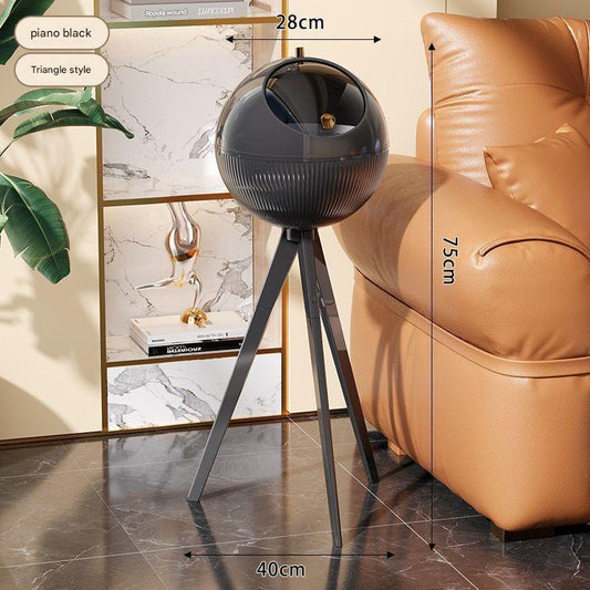 Black spherical lamp on a stand with dimensions indicated, placed in a room with a beige sofa and decorative items.