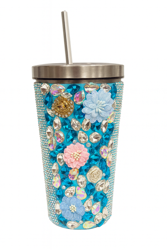 Decorative tumbler with flowers and rhinestones on a white background