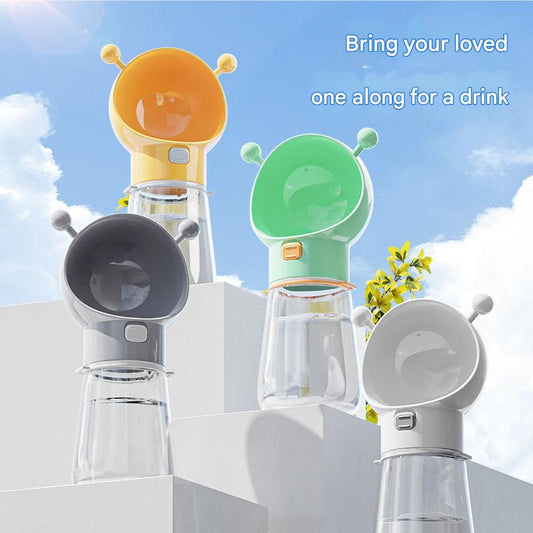 Colorful pet water bottles with animal-shaped nozzles on a white platform against a blue sky.