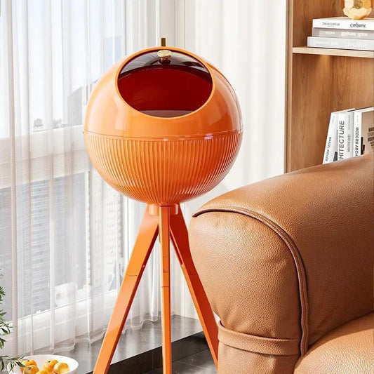 Orange spherical lamp on a tripod stand in a living room setting