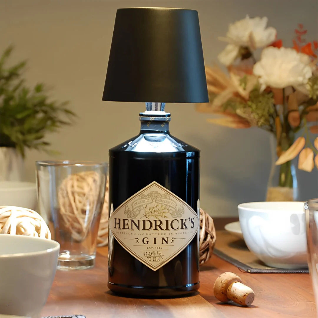 Hendrick's Gin bottle repurposed as a lamp on a table with decor items.