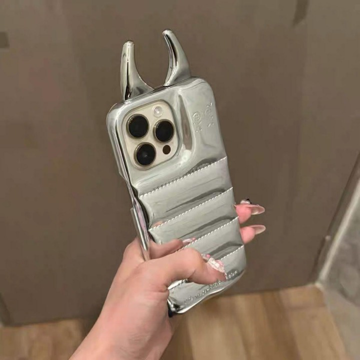Silver phone case with unique design held by a hand against a neutral background
