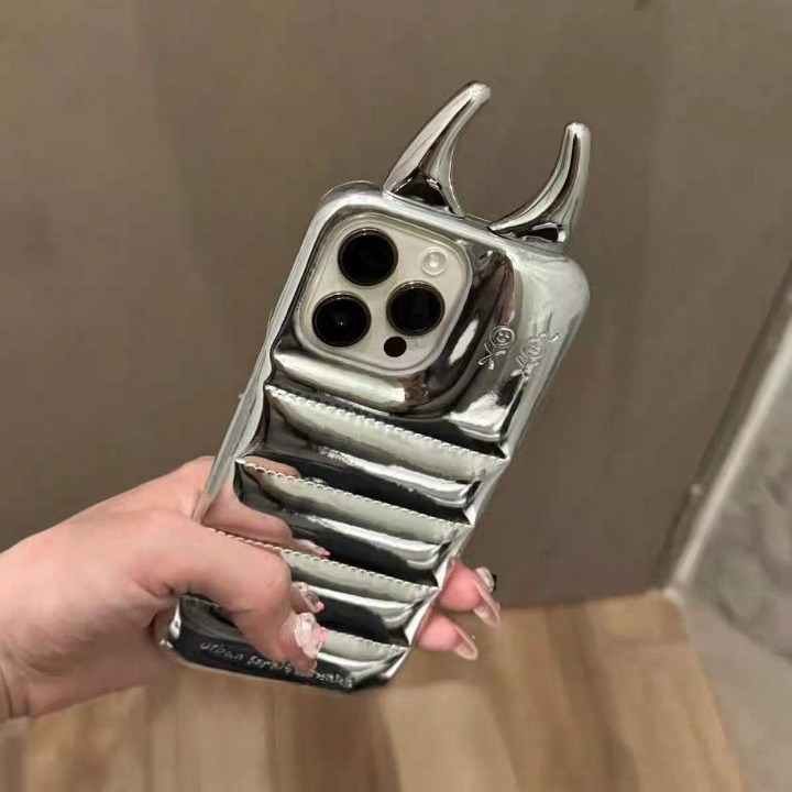Metallic phone case with unique design held by a hand against a neutral background
