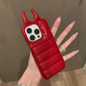 Red phone case with a unique design held by a hand against a neutral background