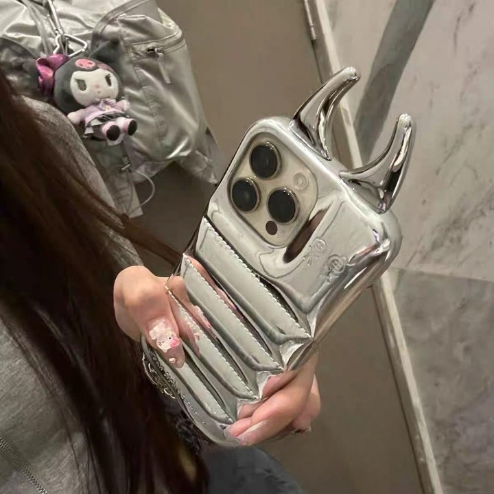Person holding a silver phone case with a unique design