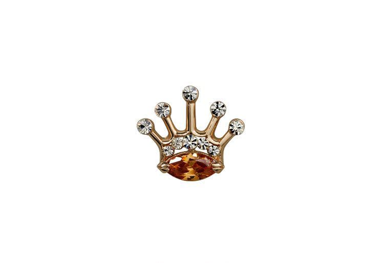 Gold crown-shaped jewelry with embedded stones on a white background