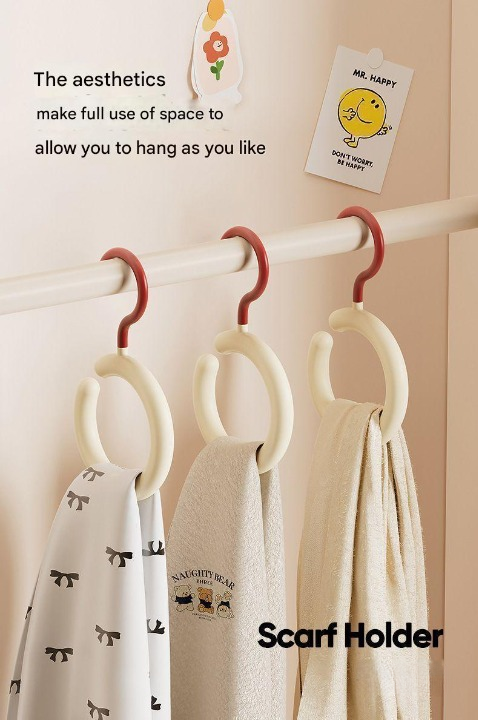 Scarf holder with scarves and a decorative card on a beige wall.