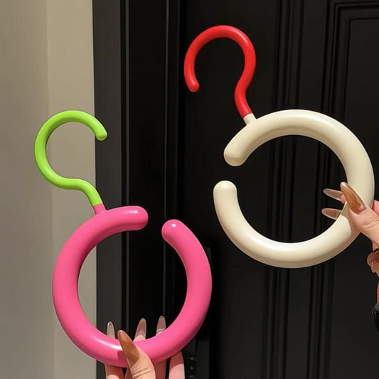 Colorful balloon arch hooks against a black door.