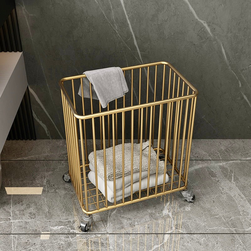 Gold metal basket with towels on a gray marble floor