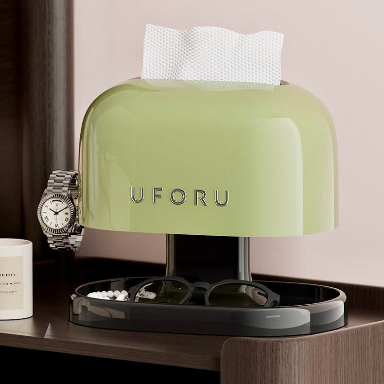 Green UFORU device on a table with a watch, sunglasses, and small container.