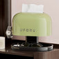 Green UFORU device on a table with a watch, sunglasses, and small container.