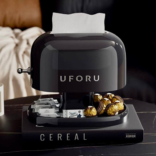 Black UFORU cereal dispenser with gold and silver cereal boxes on a dark surface.