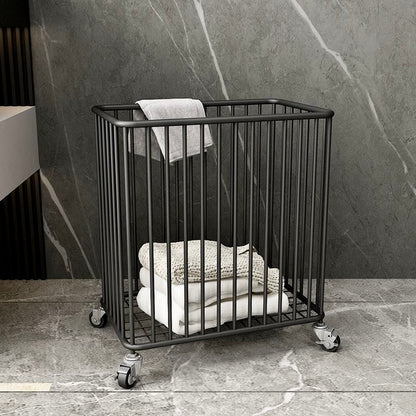 Black metal basket with towels on a stone floor against a marble wall