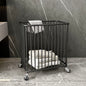 Black metal basket with towels on a stone floor against a marble wall